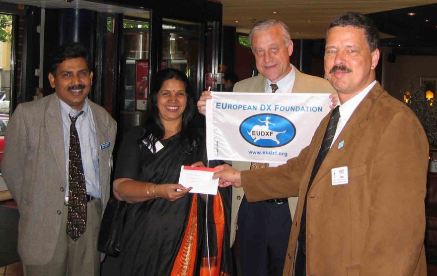 Jukka OH2BR holding the small flag while Hans PB2T hands over EUDXF support for VU4-expedition to Bharathi VU2RBI (with her husband VU2DBP Prasad)